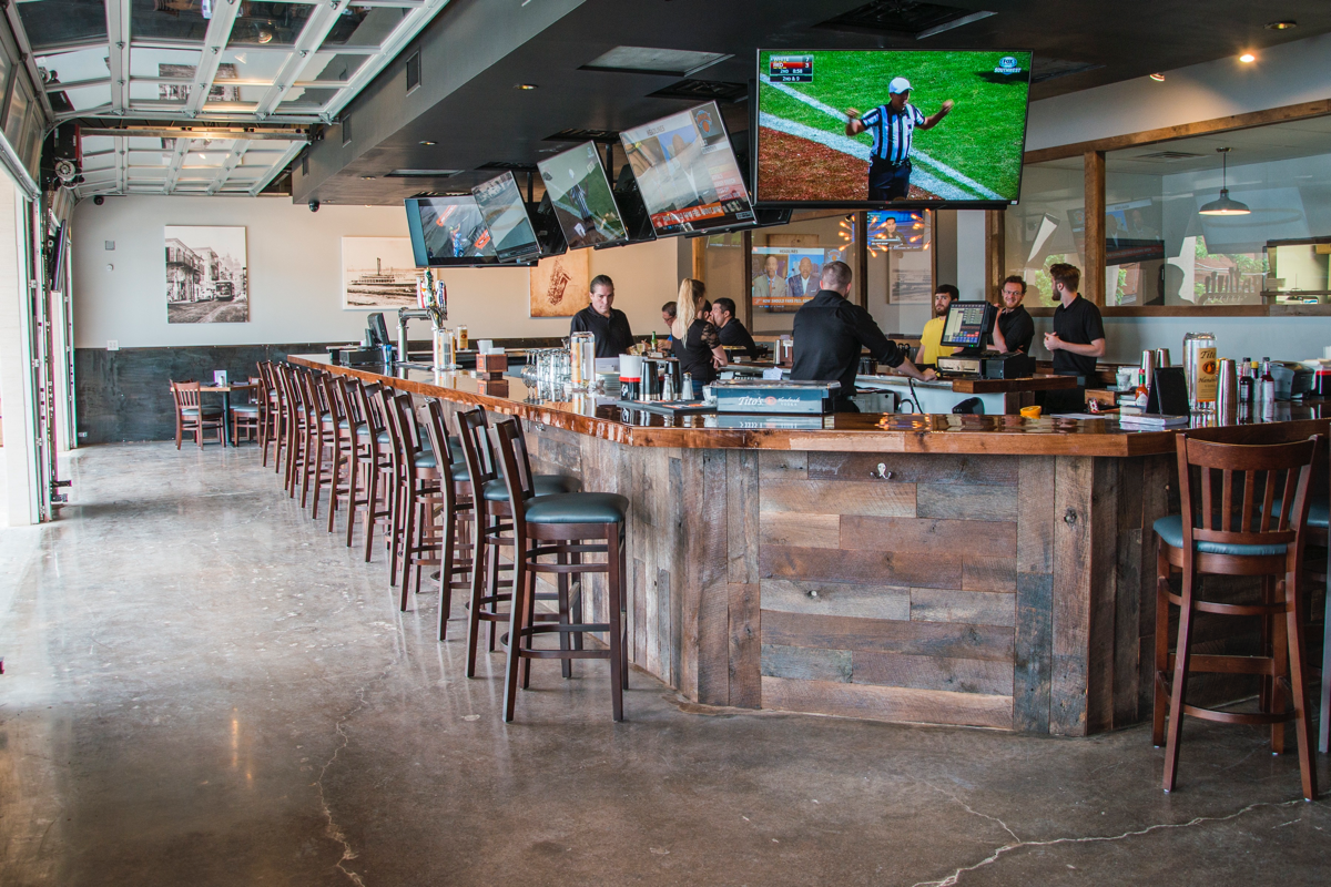 Dallas’ 504 Bar & Grill has a rustic contemporary feel, with industrial features, garage doors and sliding barn doors that create an open-air space anchored by a four-sided bar.