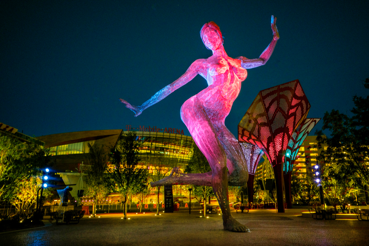The Park features a desert landscape with indoor and outdoor seating areas and decorative elements, including a 40-foot-tall sculpture of a dancing woman.
