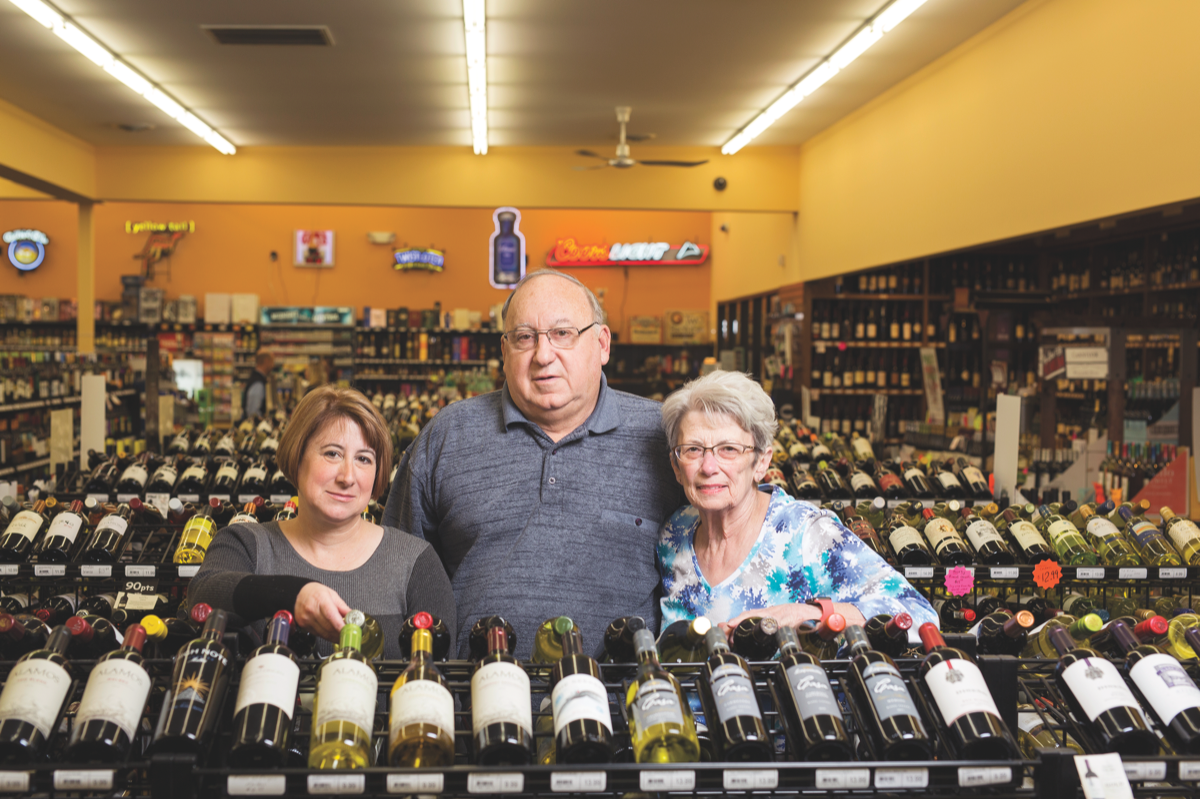 Charlie Key (center) founded Payless Liquors over four decades ago. He runs the company with his wife, Linda Key (right), and daughter, Liz Key (left).