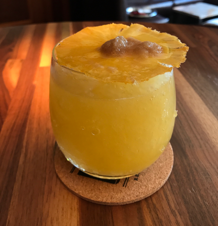 MKT's Island Fever blends aged dark rum, house-made passion fruit syrup, and fresh squeezed orange and lime juices. House-made pineapple wafer crisps are set ablaze with brown sugar and Everclear and added as a garnish.