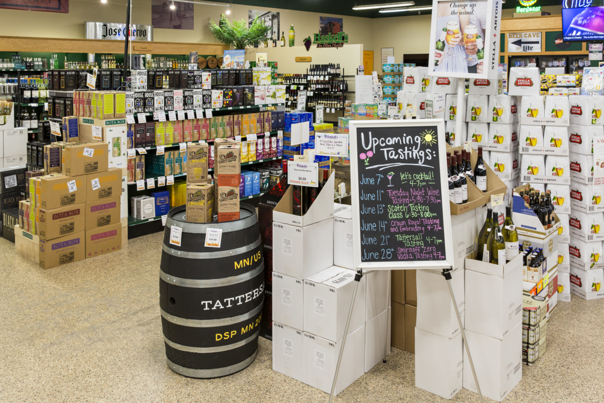 Haskell’s puts major emphasis on tastings (signage and display pictured), hosting as many as 25 wine, spirits, and beer events each week across all 11 Haskell’s locations.