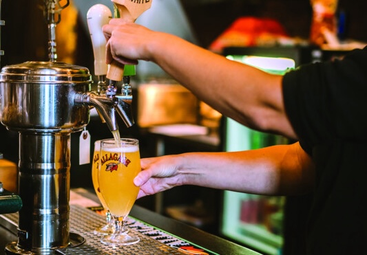 Even though beer is showing positive growth this year on-premise, producers like Allagash Brewing Co. (draft pour pictured) note that there are headwinds, including economic woes and a general slowing of dining out trends as people navigate the current climate.
