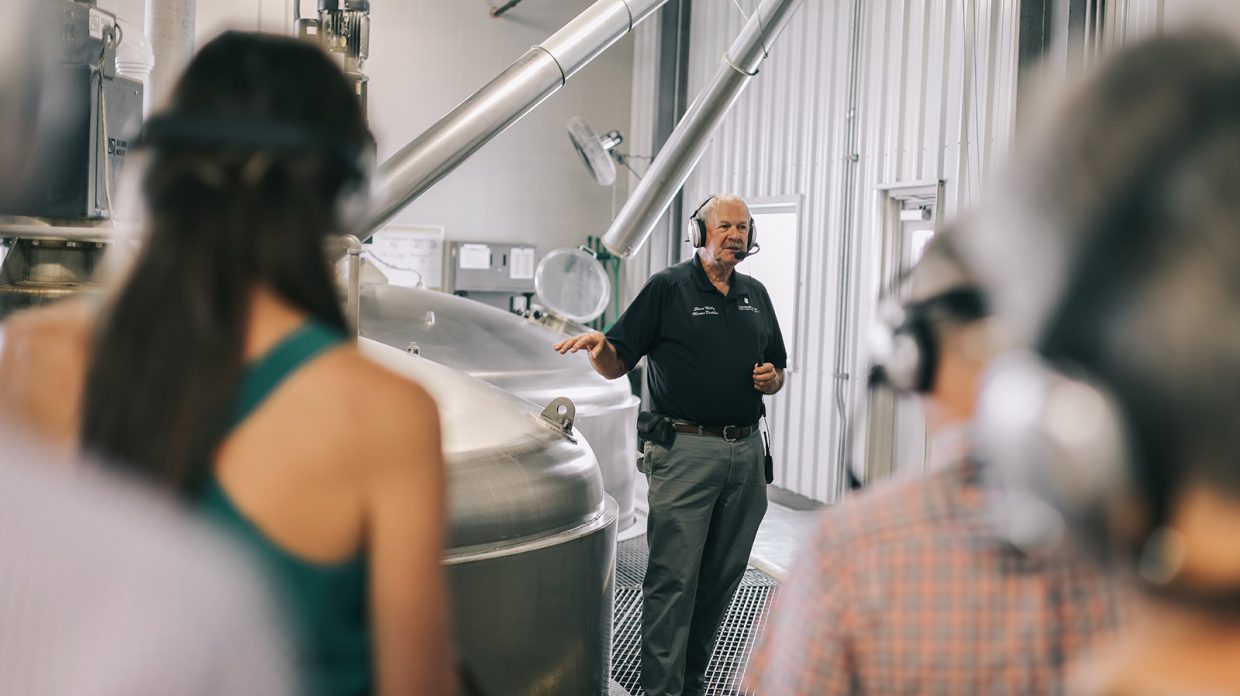 Master distiller Steve Nally stands next to distilling machinery at Bardstown Bourbon Co., while leading a tour.