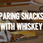 the words pairing snacks with whiskey atop an image of snacks