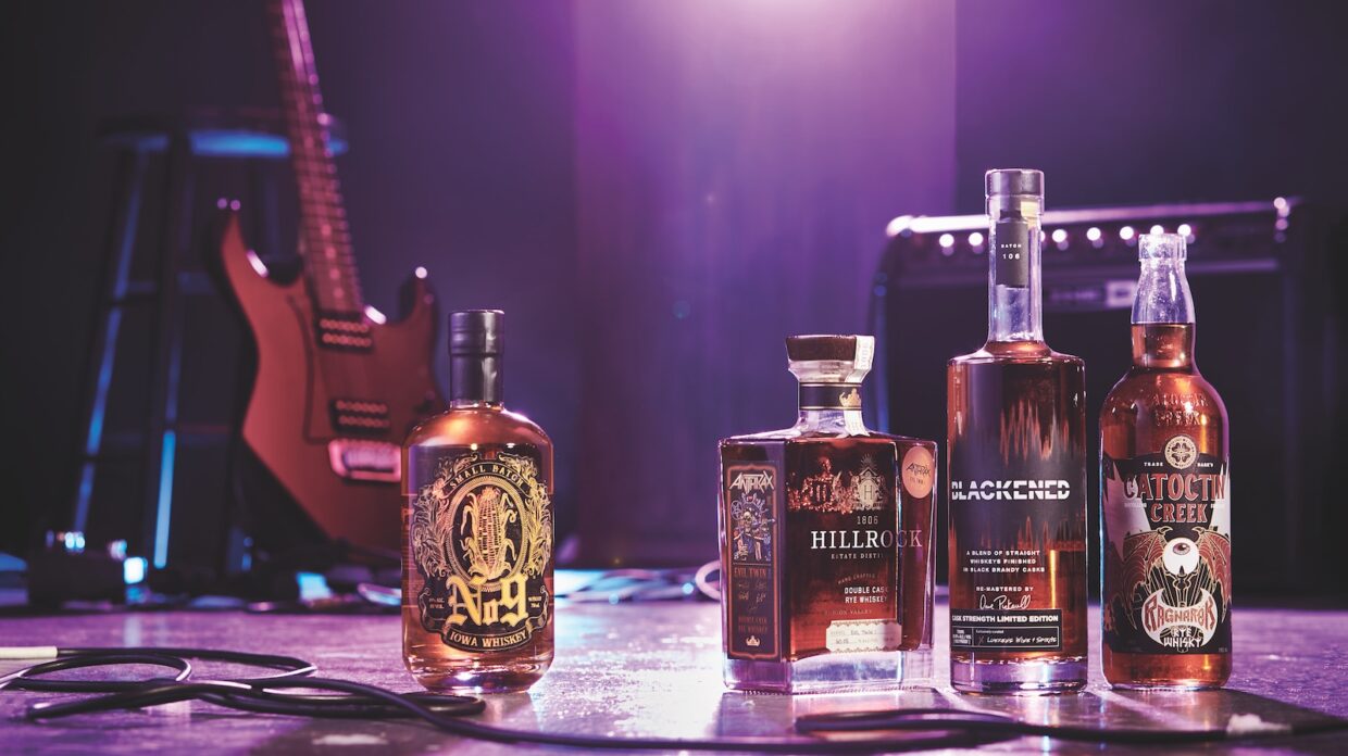 Bottles of whiskey on a stage with a guitar and amplifier